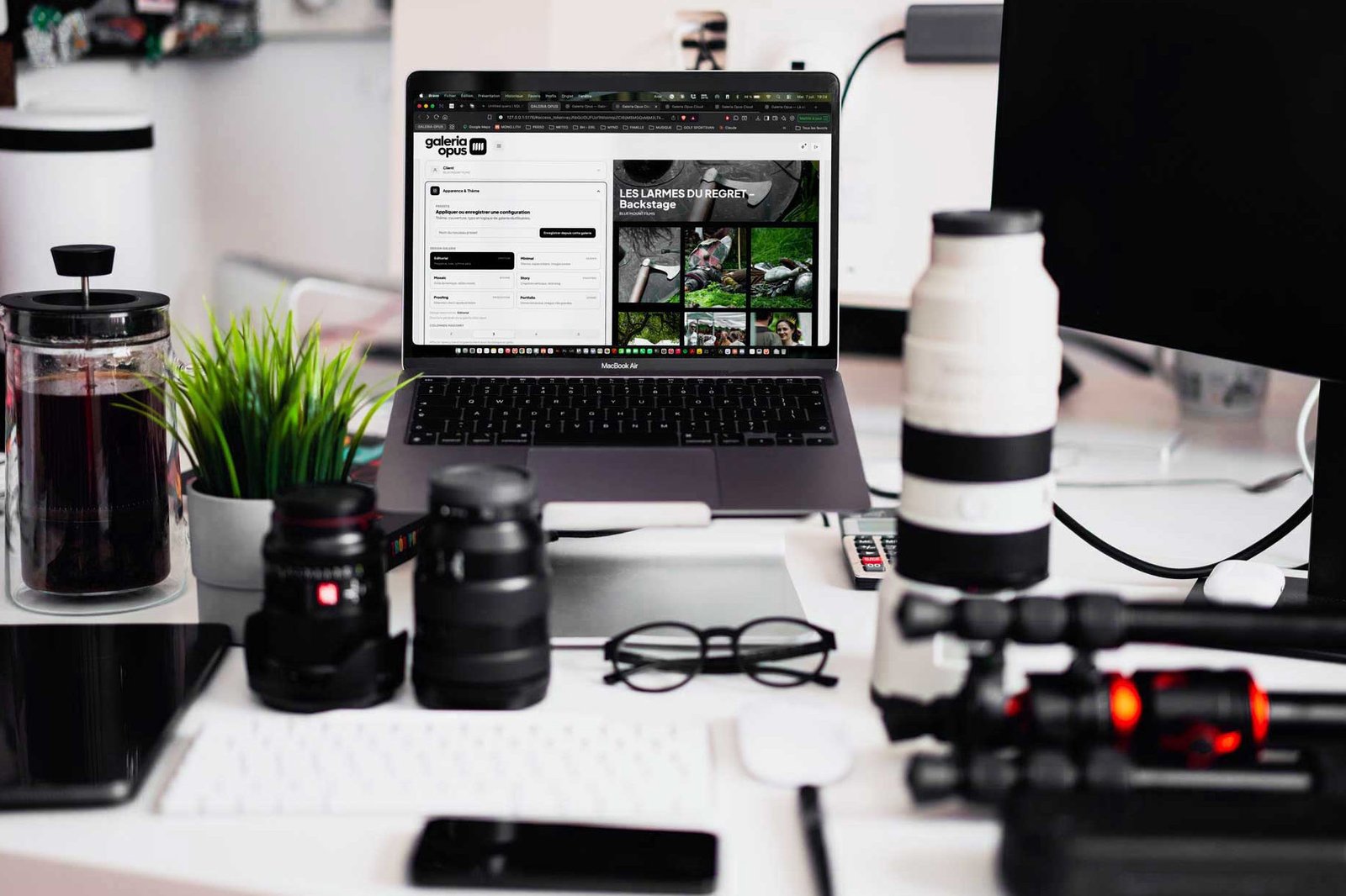 Espace de travail d'un photographe avec ordinateur, appareil et objectifs